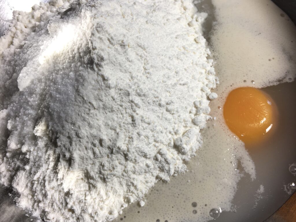 イーストの中に卵黄、水、砂糖、強力粉、塩を入れる